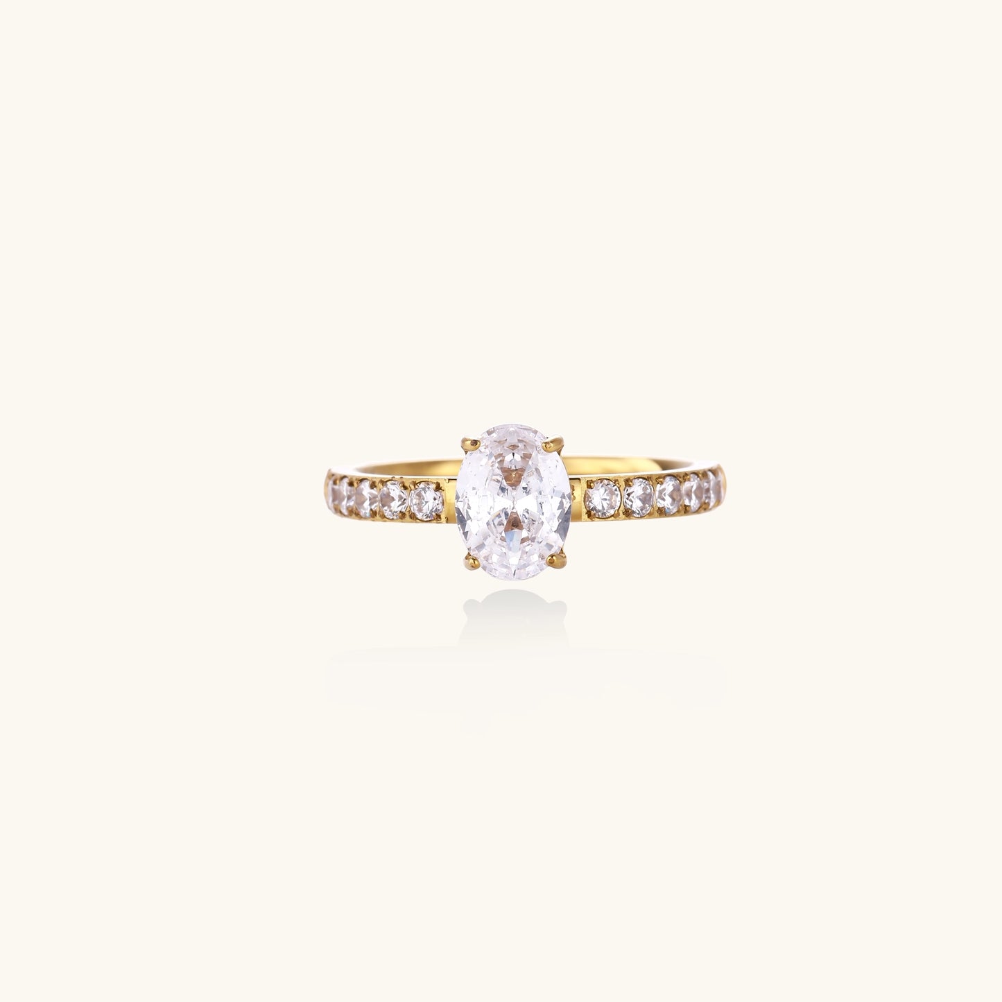 14K gold-plated ring with oval zirconia center stone and pavé band accent stones on white background.