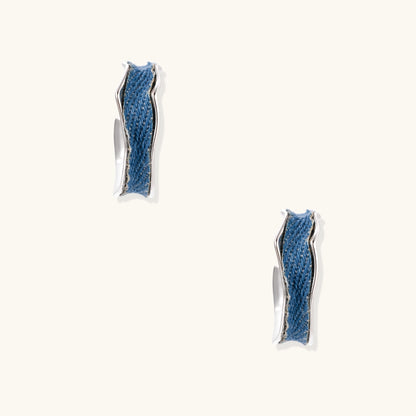 Small gold-plated hoop earrings with blue denim fabric insets on white background, showing casual-luxe styling.