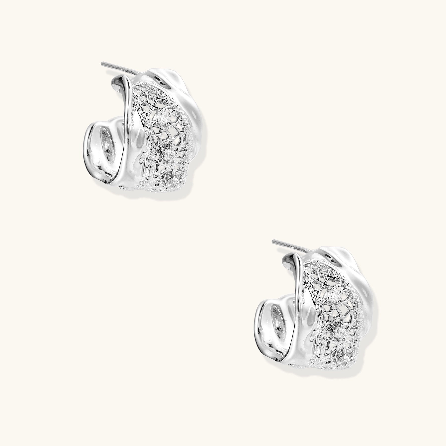 Small gold-plated brass hoop earrings with geometric lattice pattern and zirconia accents on white background.