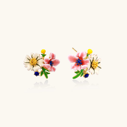 Detailed view of gold-plated brass stud earrings featuring multicolor enamel flowers with white, pink, and blue petals