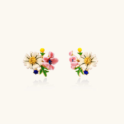 Detailed view of gold-plated brass stud earrings featuring multicolor enamel flowers with white, pink, and blue petals
