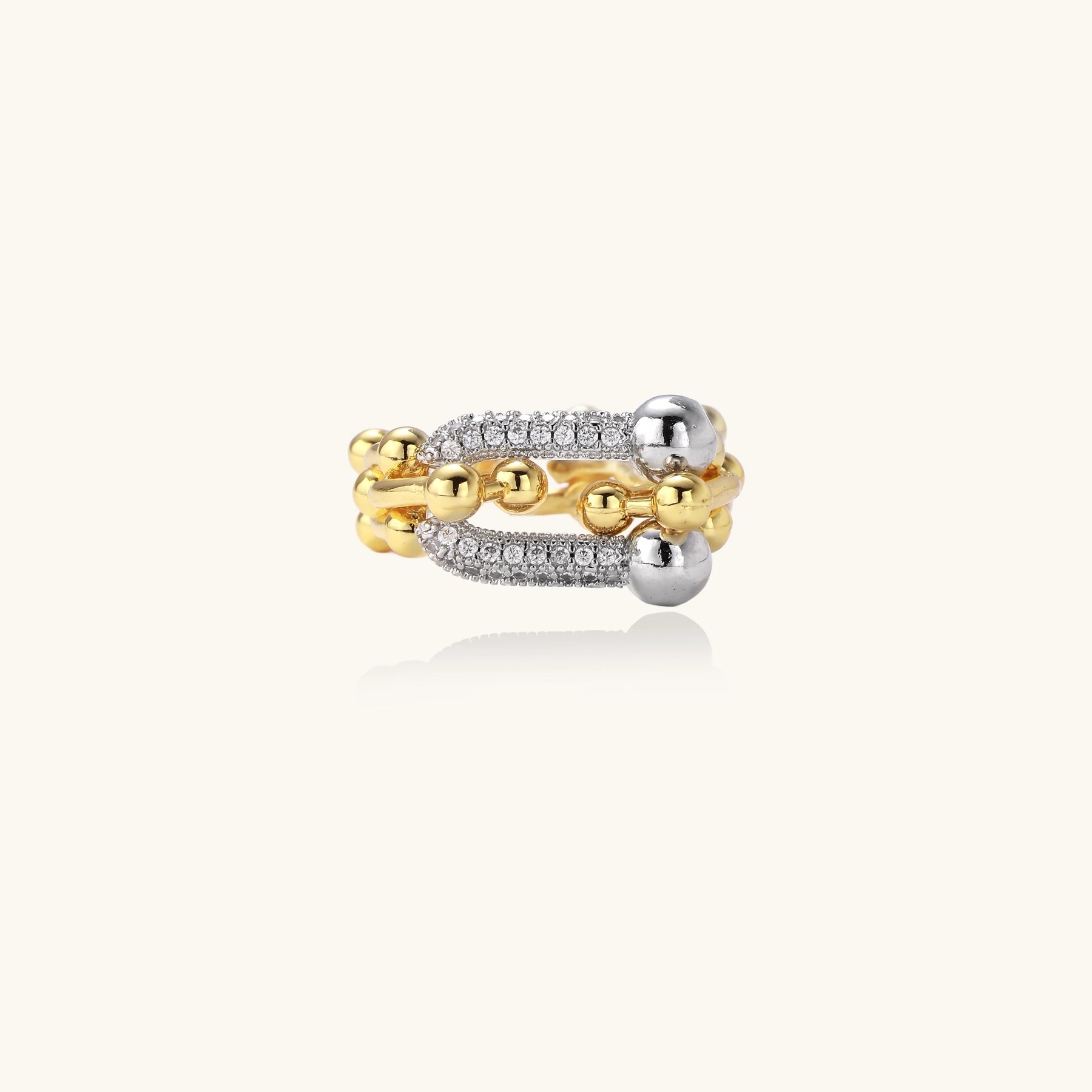 Bold gold-plated chain-link ring with cubic zirconia bars and sphere details on white background.