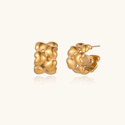 Small gold-plated hoop earrings with intricate braided texture pattern and post backs on white background.