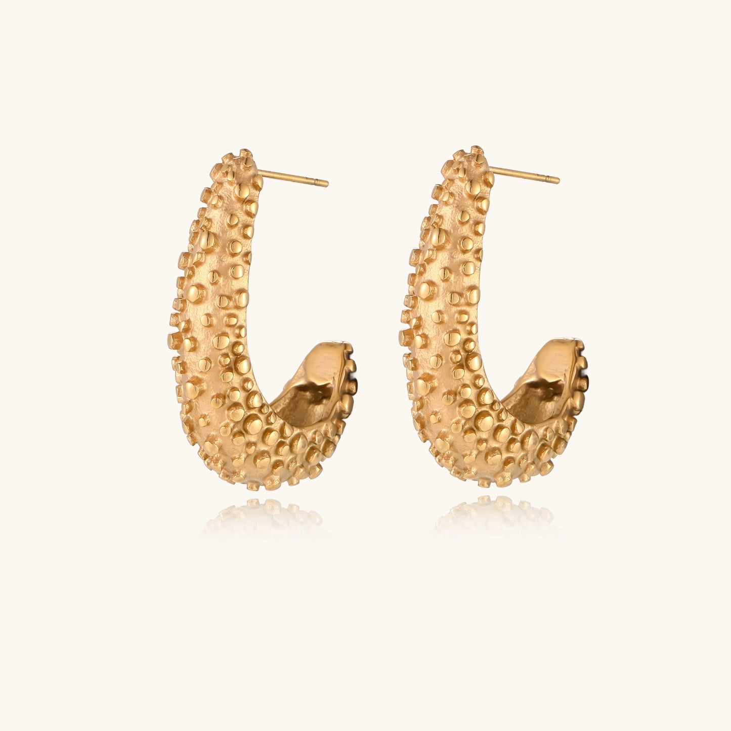 Pair of gold-plated hoop earrings with raised dotted texture surface shown from multiple angles on white background.