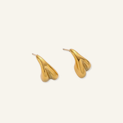 Pair of gold-plated sculptural stud earrings with organic teardrop shapes on neutral background.