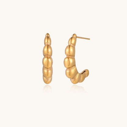 Gold-plated stainless steel hoop earrings with segmented bubble design and post closure on white background